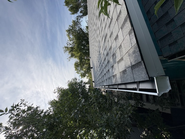 Shingles meeting the eavestrough at the roof edge
