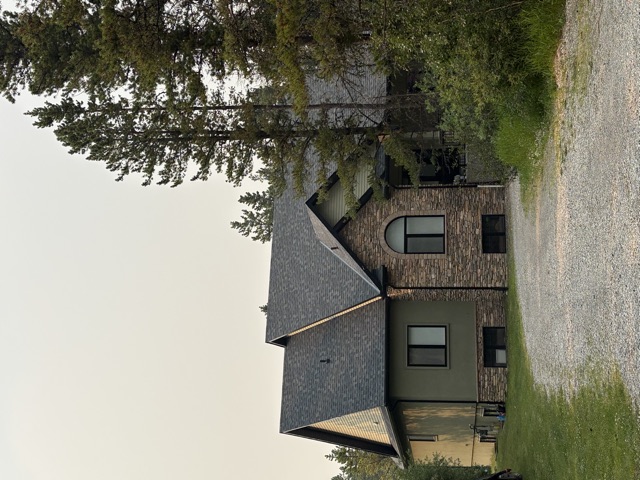 Stone and stucco house, dark shingle roof