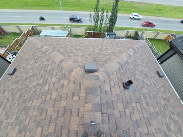 Shingle roof ridge, street below