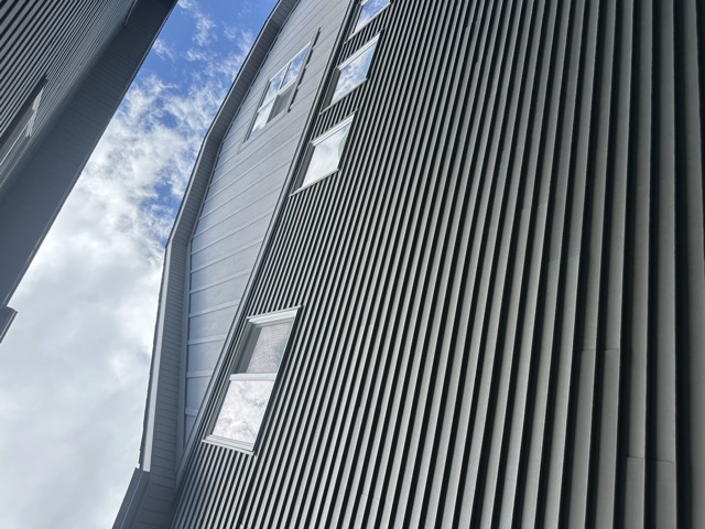 Navy siding with a board-and-batten panel above the windows