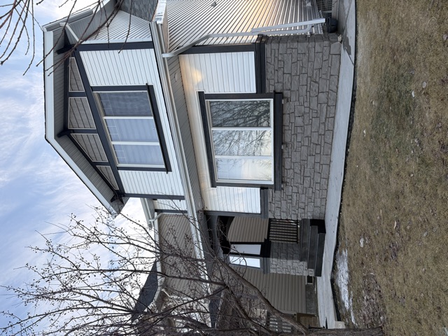 Grey siding with a stone base