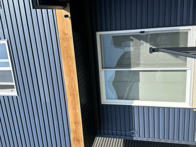 Navy siding and a window with a wood band