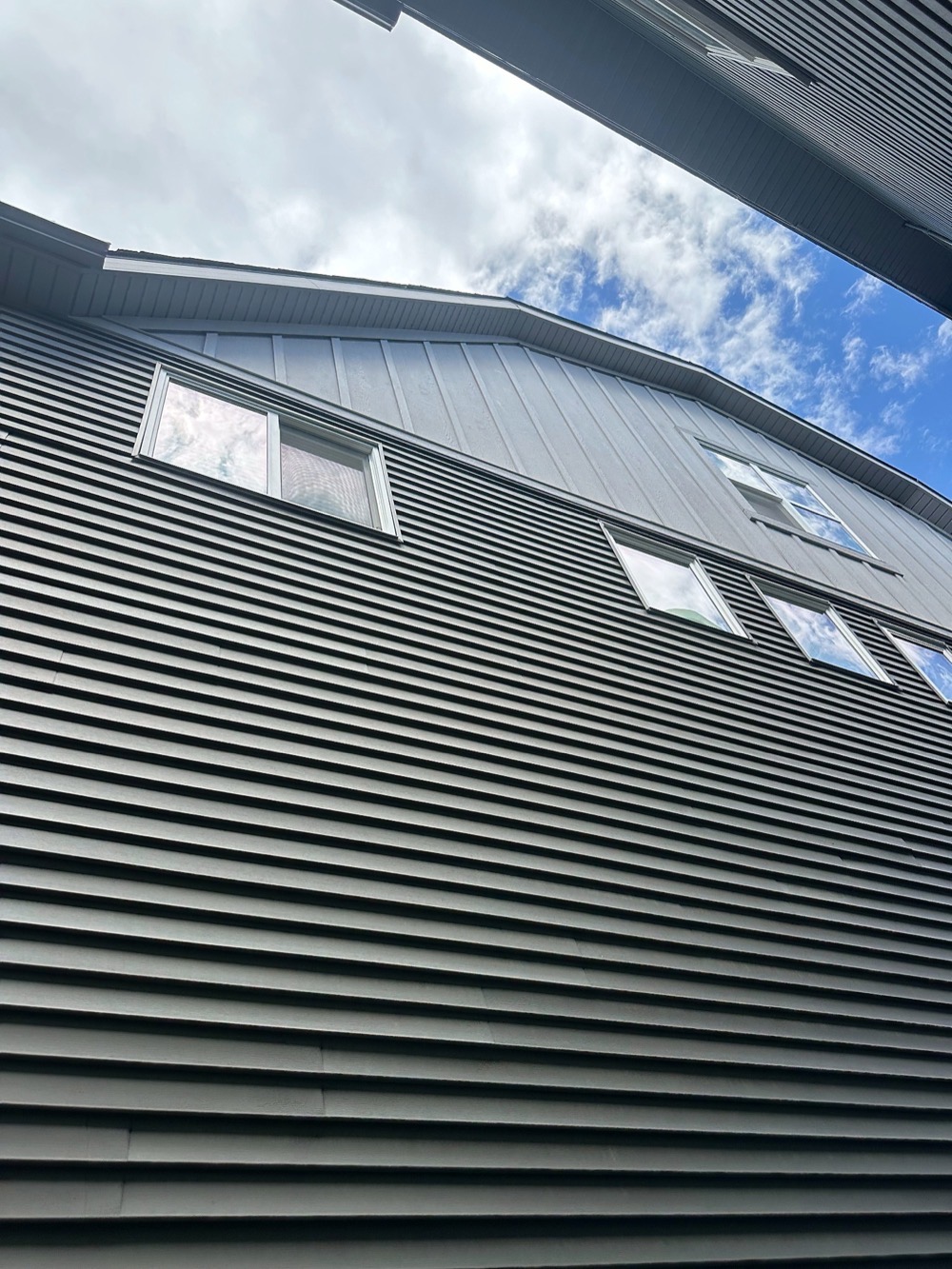 Navy horizontal siding with a board-and-batten panel above the windows